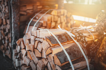 A package of dry firewood for heating the house. A bundle of firewood. Beech wood in a package. - obrazy, fototapety, plakaty