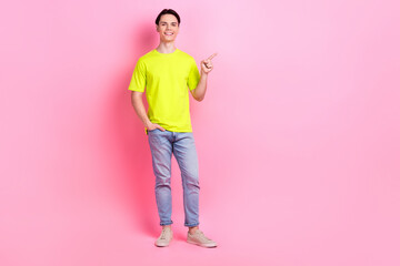 Full length photo of cheerful good mood man dressed yellow t-shirt showing finger empty space...