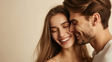 A close-up of a happy couple sharing a tender moment with the man kissing the woman's cheek both smiling and looking away from the camera set against a soft neutral background.