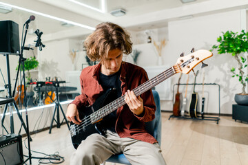 rock artist with long hair with electric guitar during rehearsal playing own track musical...