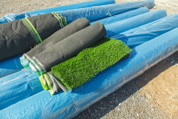 Artificial grass and gravel. Artificial grass rolls. Artificial turf installation.