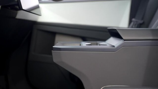 Close-up of details of a futuristic electric car with an angular design displayed outdoors.