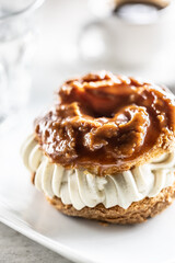 Veternik - sweet donut, typically Slovak caramel sweet cake with cream filling topped with caramel on a plate in a cafe