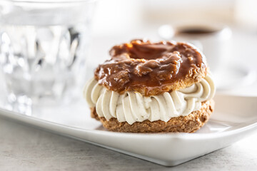 Veternik - sweet donut, typically Slovak caramel sweet cake with cream filling topped with caramel on a plate in a cafe