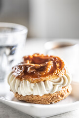 Veternik - sweet donut, typically Slovak caramel sweet cake with cream filling topped with caramel on a plate in a cafe