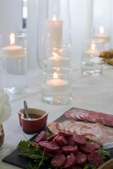 Delicious sliced Portuguese sausages elegantly arranged near candles on a wedding table, capturing culinary tradition and festive atmosphere