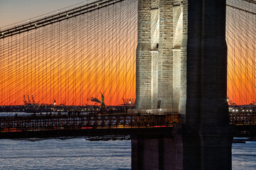 Brooklyn Bridge and Statue of Liberty illuminated at sunset. Close-up of two historical New York...