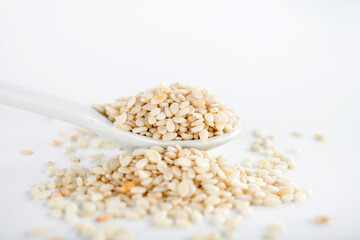 Close-up of sesame seeds in a white ceramic spoon