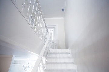 Luxurious modern interior design in a multi-storey building with an elegant white wooden staircase with details