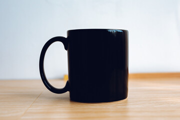 1 black mug with a wooden floor and white background.