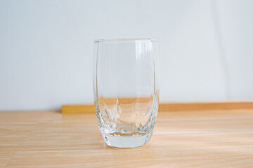 1 clear glass, wooden floor and white background.