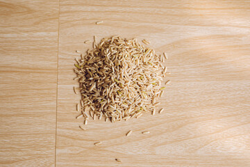 1 pile of brown rice with a wooden background.