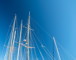 several masts of a yacht without sails