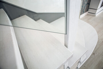 Fototapeta premium Luxurious modern interior design in a multi-storey building with an elegant white wooden staircase with details