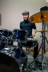 bearded male musician during rehearsal plays drums musical instrument drumsticks music concert