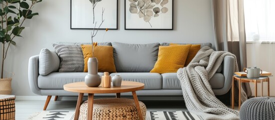 The contemporary boho living room interior features a gray sofa, wooden coffee table, rattan basket, and stylish personal accessories like a honey yellow pillow and plaid. It creates a cozy atmosphere
