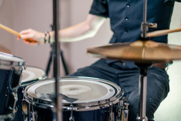 close-up musician during rehearsal plays drums musical instrument drumsticks music concert