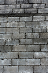 A grey concrete brick textured wall in India. Interiors and decoration.