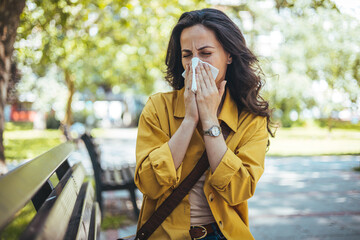 Woman has sneezing. Young woman is having flu and she is sneezing. Sickness, seasonal virus problem concept. Woman being sick having flu sneezing. - obrazy, fototapety, plakaty