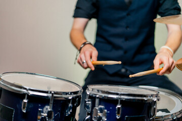 Fototapeta na wymiar close-up musician during rehearsal plays drums musical instrument drumsticks music concert