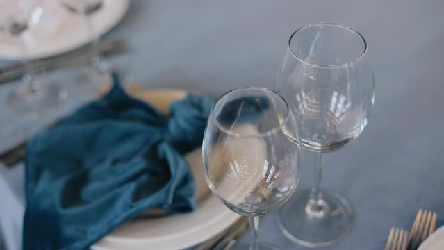 A close-up of two glasses standing on a festive table. The camera moves smoothly taking pictures of the table