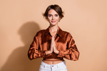 Photo of adorable cute girl wear brown blouse practicing yoga hands arms together isolated beige...