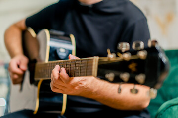 musician with electric guitar in recording studio plays musical instrument presses fingers on...