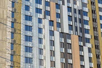 Modern Building Under Construction with Insulation Layers Exposed Facade Works