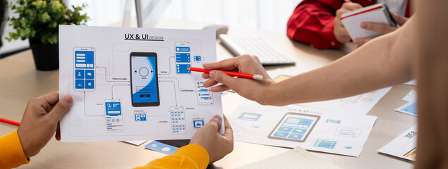 Panorama banner of startup company employee planning on user interface prototype for mobile application or website in office. UX UI designer brainstorm user friendly interface plan. Synergic