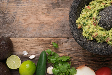 Delicious guacamole with organic blue corn chips in a molcajete bowl.  Ingredients to make...