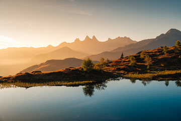 Golden sunrise over Arves massif with lonely tree relfection on Lac Guichard at French Alps - obrazy, fototapety, plakaty
