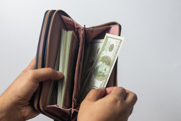 Money is being withdrawn from a wallet by a man of mixed racial background.