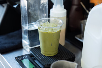 Iced green tea with ice cube in plastic glass