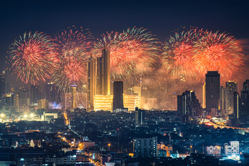 New year festival with firework display glowing over department store, illuminated building in downtown during midnight time at Bangkok, Thailand