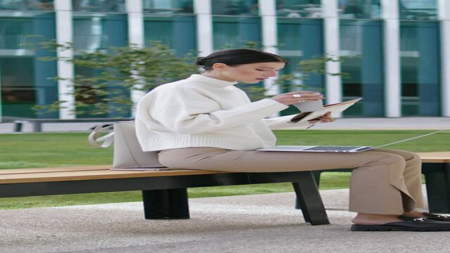 Student taking coffee break from online studying sitting bench vertical oriented