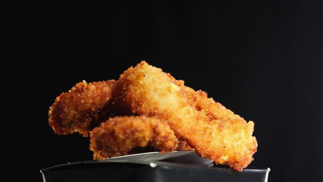 Meaty chicken wings in batter. 360 degree close up view on black background. Concept of delicious food and deep frying dishes