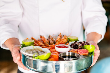 chef hold Set Mixed Seafood on plate