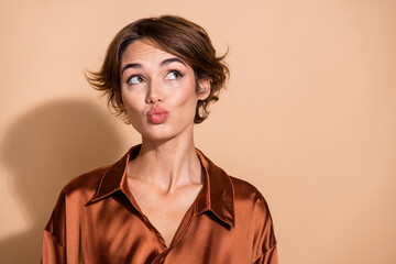 Photo of impressed flirty woman wear silky blouse pouted lips looking empty space isolated beige color background