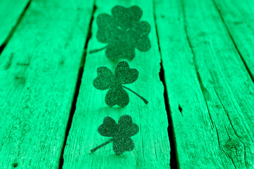 St. Patrick's day. Decorative clover leaves on green wooden background