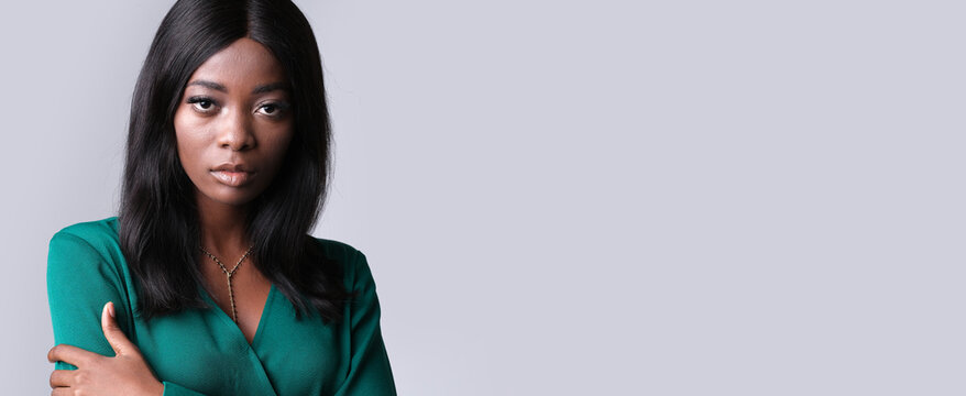 Woman with a serious face on a gray background.