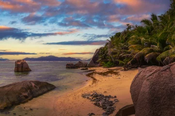 Papier Peint photo autocollant Anse Source D'Agent, île de La Digue, Seychelles Sunset over Anse Source D'argent beach at the La Digue Island, Seychelles, with calm water of the Indian Ocean, amazing granite rock formations and mountains in the background.