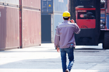 Engineer wearing safety helmet working at shipping container.