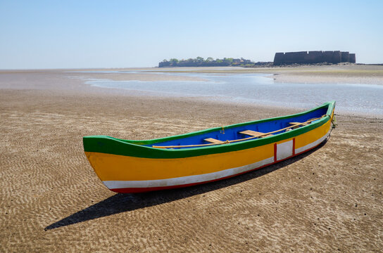 Colorful boat on the Alibaug beach and Alibaug Fort in the background, Alibaug, Maharashtra, India, Asia.