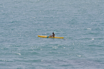 Person sailing a kayak in the middle of the sea