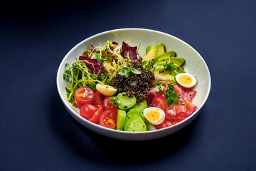 Bowl with salmon, quinoa and avocado on a blue background