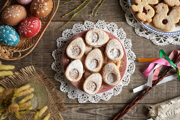 Homemade Linzer cookies and Easter eggs decorated with wax on a table