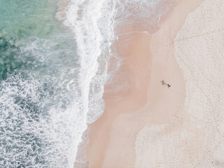 Fototapeta na wymiar Surfista en la playa, drone estilo pastel
