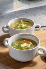 Two portions of mushroom soup in identical tureens. Vertical. Preparing meal at home. Oyster mushroom soup