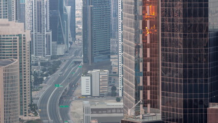 Obraz premium Aerial view from above to a busy road intersection in Dubai night to day timelapse.