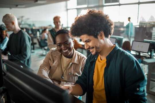 Diverse young students using computer in university lab